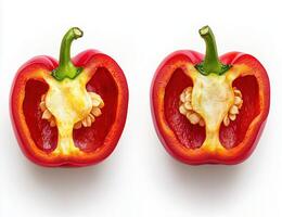 Two red bell peppers are sliced in half and placed side by side. The white seeds and inner flesh are clearly visible against a white background. photo