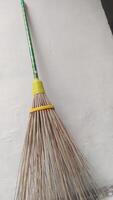 a broom with a yellow handle and a green handle, close-up photo