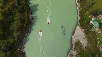 Aerial view top down on the turquoise river with a motor boat video