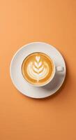 A cup of coffee with a leaf design on top of a saucer photo