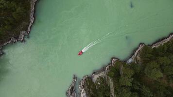 Aerial view top down on the turquoise river with a motor boat video