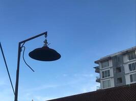 Lamp hanging from a pole in front of a building photo