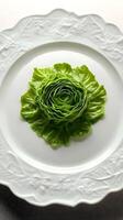 Creative presentation of lettuce arranged as a rose on an elegant white plate in a dining setting photo