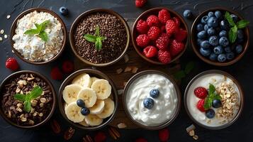 Fresh and colorful assortment of healthy breakfast bowls featuring fruits, yogurt, oats, and nuts arranged on a dark surface photo