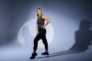 Confident dancer posing in studio with projected shadows photo