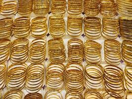 Gold Bracelets. jewelry for sale in market. elegant gold jewelry in the largest market. Rows of gold bracelets in a store. photo