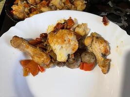 Chicken baked with vegetables in a rustic kitchen setting photo