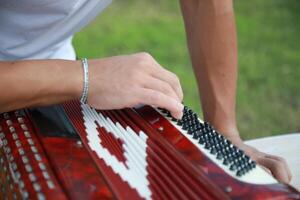 Man Testing All The Buttons Of His Accordion photo