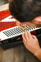 Man Using Tool To Fix And Tune Accordion photo