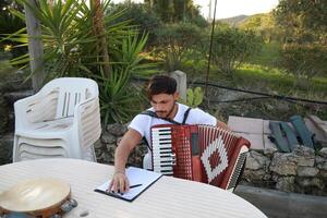 hombre estudiando acordeón y acecho en el papel foto