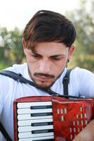 Man Studying Accordion And Watching On The Paper photo