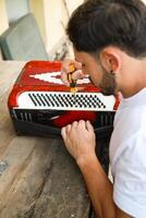 Man Using Tool To Fix And Tune Accordion photo