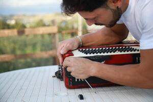 hombre utilizando herramienta a reparar y melodía acordeón foto