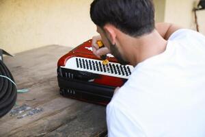 Man Using Tool To Fix And Tune Accordion photo