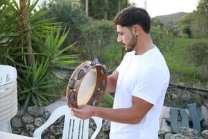 Happy Tambourine Player Performing in Fields photo