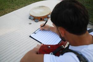 Man Studying Accordion And Watching On The Paper photo