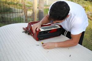 Man Using Tool To Fix And Tune Accordion photo