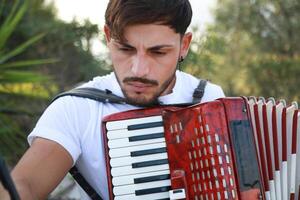 Man Studying Accordion And Watching On The Paper photo