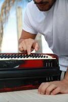 Man Testing All The Buttons Of His Accordion photo