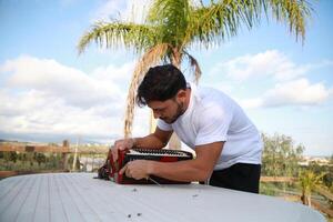 Man Using Tool To Fix And Tune Accordion photo