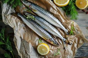 Fresh saury fish lying on baking paper with dill and lemon slices photo