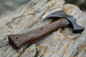 Handcrafted axe resting on weathered wood surface photo