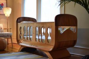 Modern wooden baby crib resting in a warm sunlit nursery photo