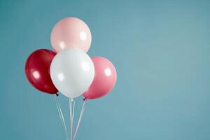 Bunch of colorful balloons floating on minimalist blue background photo
