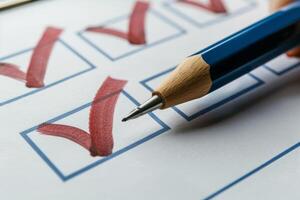 Person is checking off multiple tasks with red check marks on clipboard photo