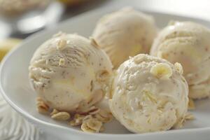 Banana ice cream scoops topped with oats and banana slices being served on white plate photo