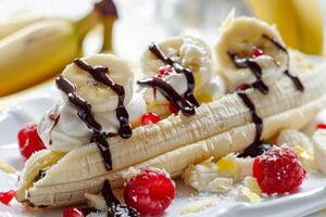 Banana split being prepared with whipped cream, chocolate sauce and raspberries photo