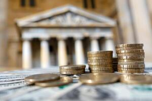 Stacks of coins showing increasing wealth and profit with a courthouse in the background photo