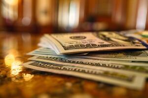Stack of one hundred dollar bills lying on table photo