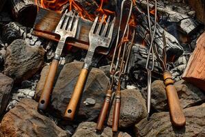 Vintage forks and barbecue tools are heating on burning firewoods photo