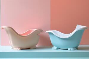 Two empty baby bathtubs with a pastel pink and peach background sitting on a turquoise surface photo