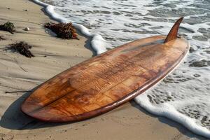 Wooden surfboard resting on the beach with ocean waves crashing photo