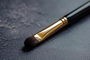 Professional makeup brush lying on dark gray surface photo