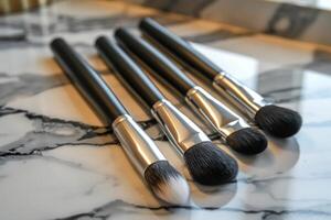 Set of makeup brushes lying on marble countertop photo