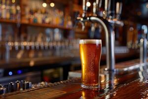 Cold beer standing on bar with taps in background photo