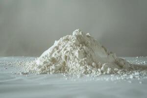 Pile of white flour is sitting on a white table photo
