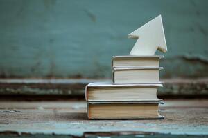 Stack of books with upward arrow symbolizing growth through learning photo