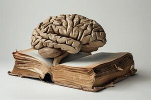 Wooden brain sculpture resting on open old book symbolizing knowledge and learning photo