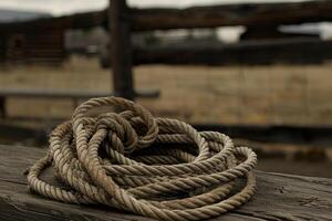 Old rope resting on wooden beam in ranch setting photo
