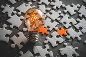 Glowing light bulb representing innovative problem solving with puzzle pieces photo