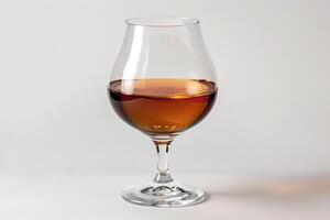 Glass of cognac or brandy standing on white background photo