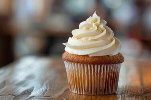Delicious cupcake with swirl frosting on rustic wooden table photo