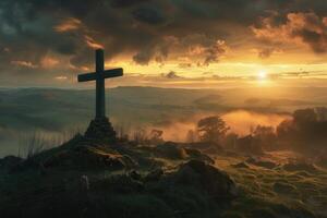 Large wooden cross standing on hilltop at sunset with valley below photo
