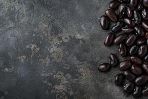 Black beans piled up on dark stone background creating negative space photo