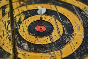 Dart hitting the center of an old target, achieving objectives with precision and accuracy photo