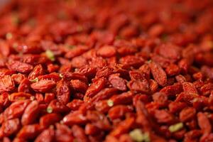 Dried goji berries filling the frame creating a vibrant red background photo
